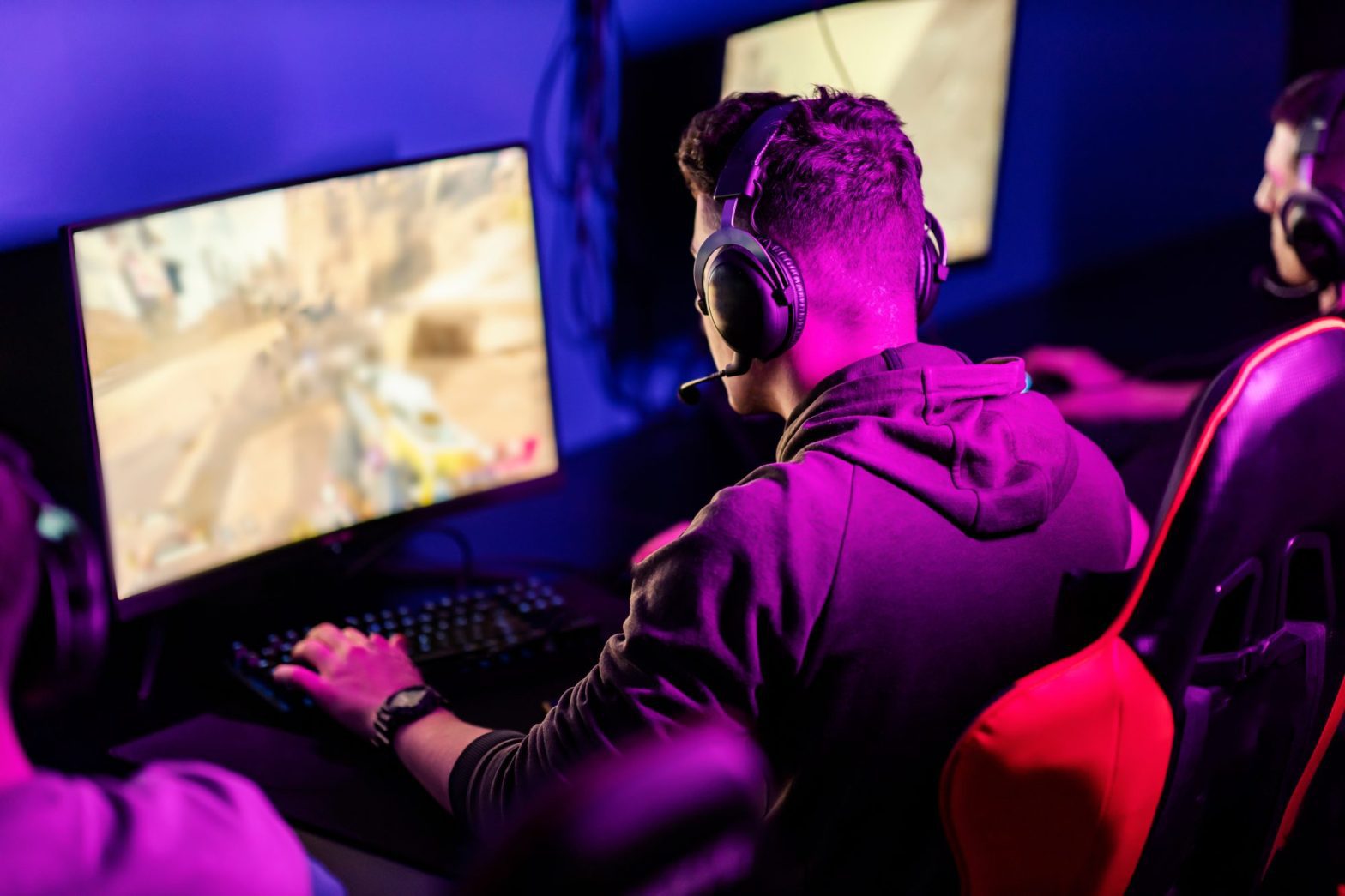In a dimly lit room, surrounded by the glow of screens, a person wearing headphones immerses themselves in intense gameplay. They're gearing up for the Corte Madera Esports Tournament, honing their skills at the Greenbrae Esports Gaming Center.