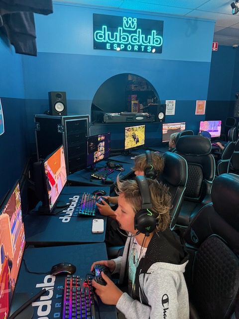 Players using controllers at DubDub AI Arcade gaming stations