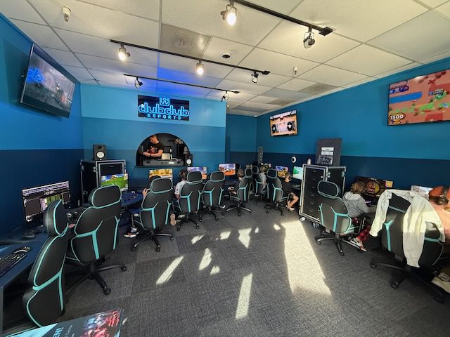 Rows of gaming stations and chairs inside DubDub AI Arcade