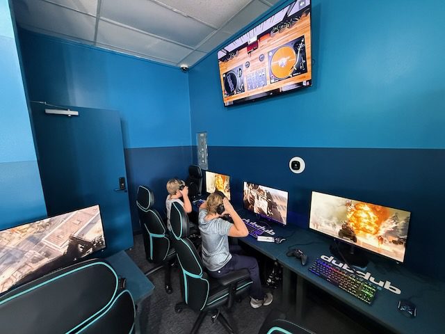 DubDub AI Arcade logo wall with gaming stations and wall screens