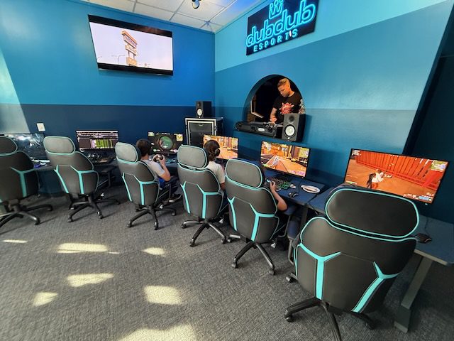 Open DubDub AI Arcade room with gaming chairs, monitors, and wall screens