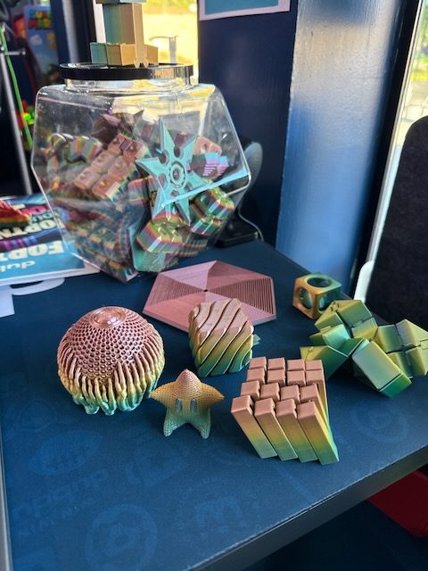 Colorful printed toys and tabletop display inside DubDub AI Arcade