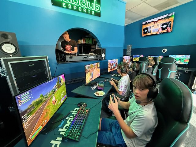 Wide view of DubDub AI Arcade gaming stations with players